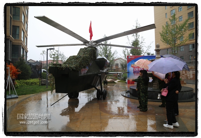 小區(qū)突然出現(xiàn)“飛機(jī)坦克”，其中殲15艦載戰(zhàn)斗機(jī)一架、99式主戰(zhàn)坦克一輛、武直-10武裝直升機(jī)一架，吸引了眾多市民雨中圍觀、合影。